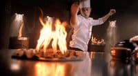 a chef standing in front of a fire in a kitchen
