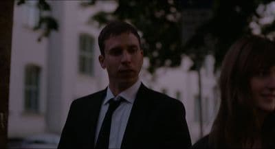 a man in a suit and tie standing next to a woman