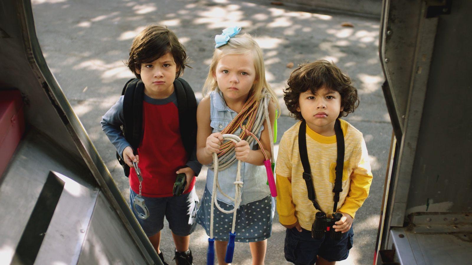 a group of three children standing next to each other