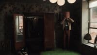a person standing in a room with a green floor