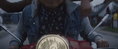 a man riding on the back of a red motorcycle