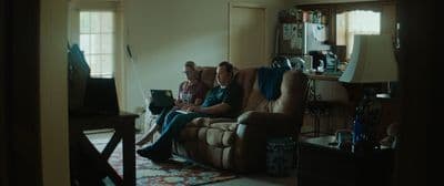 two people sitting on a couch in a living room