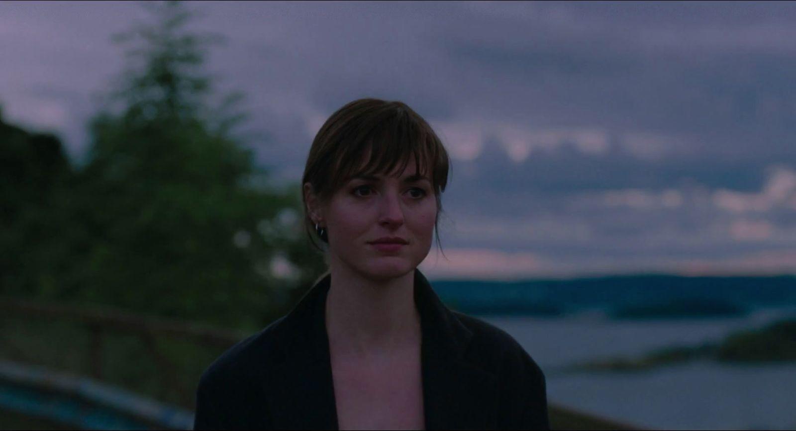 a woman standing in front of a body of water