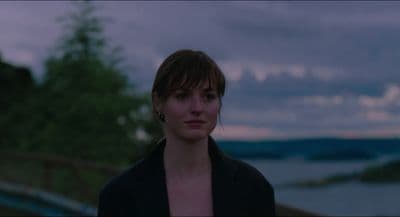 a woman standing in front of a body of water