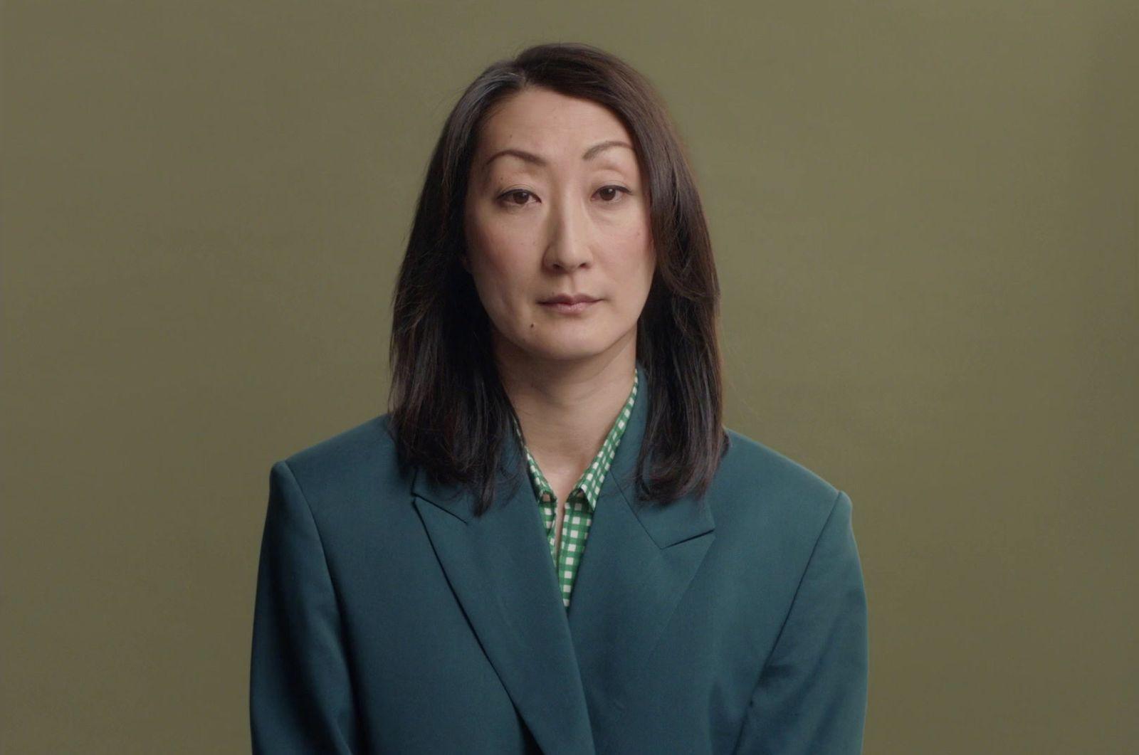 a woman in a blue suit and green shirt