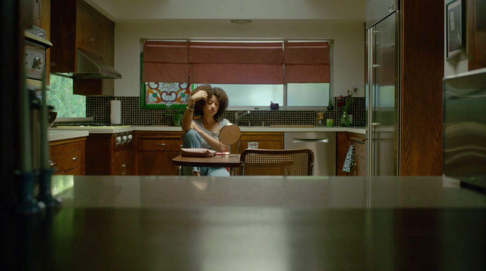 a woman standing in a kitchen next to a table