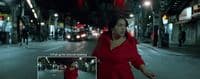 a woman in a red dress walking down a street