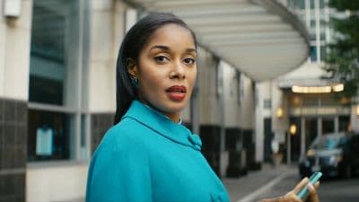 a woman in a blue coat holding a cell phone