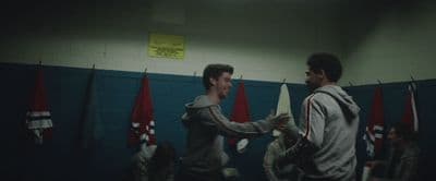 a couple of men standing next to each other in a gym