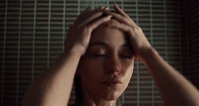 a woman with her hands on her head