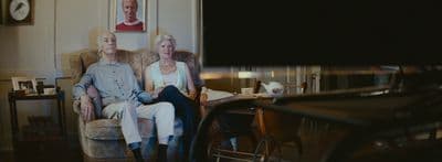 a man and a woman sitting on a couch in a living room