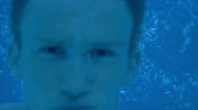 a man in a swimming pool looking at the camera