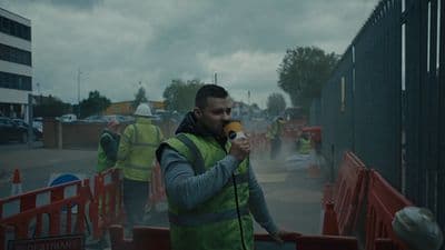 a man in a safety vest holding a microphone