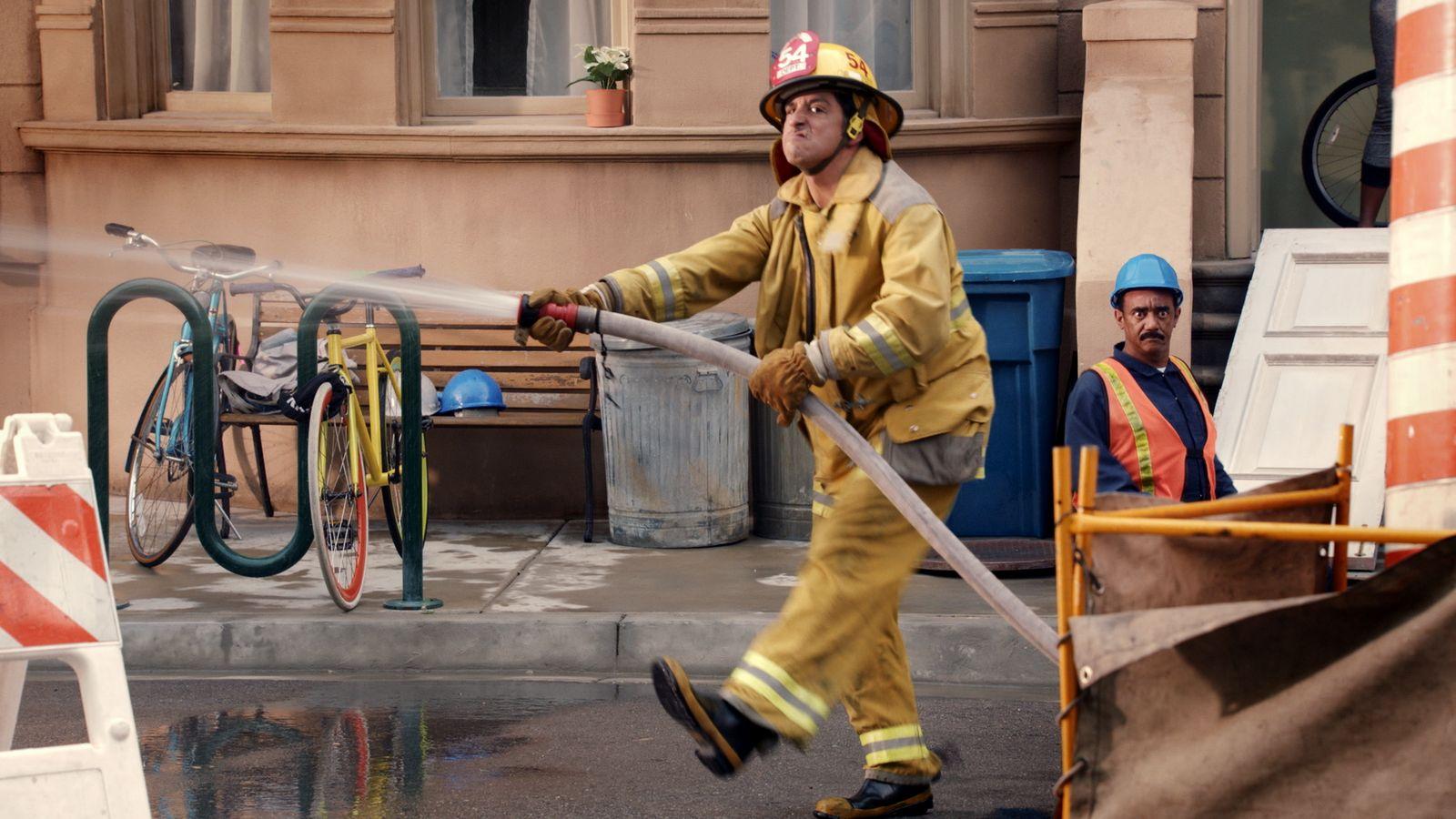 a man in a fireman's uniform is using a hose to put out