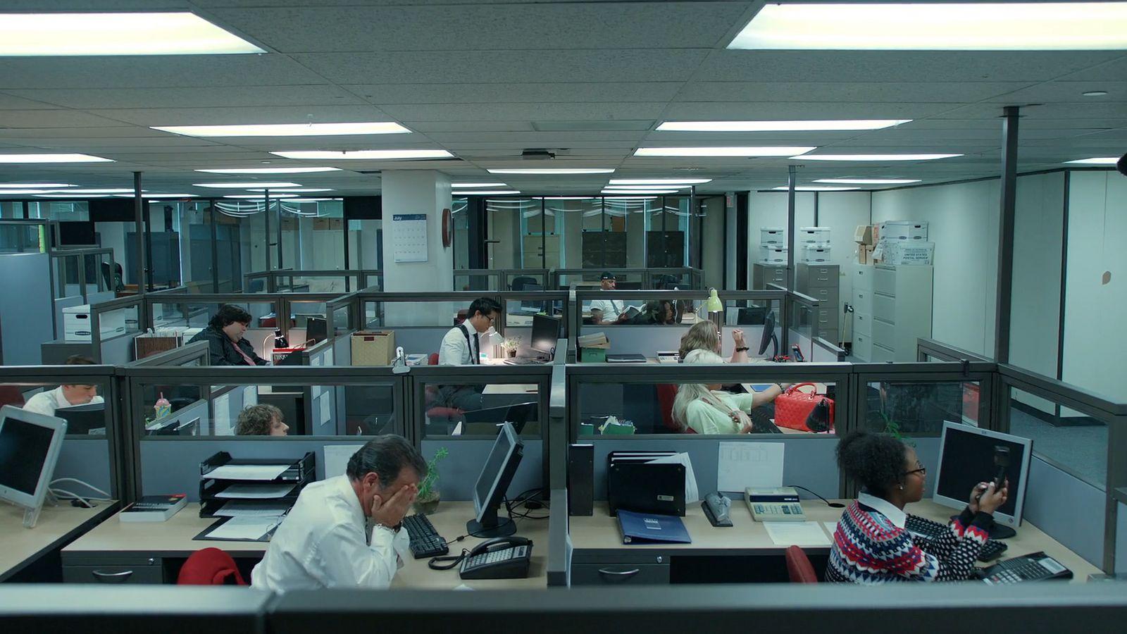 a group of people working in an office cubicle
