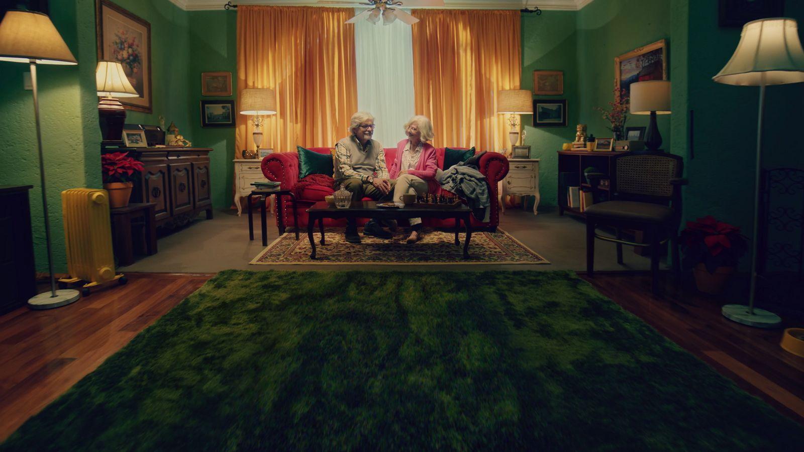 two people sitting on a couch in a living room