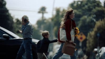a woman and two children crossing the street
