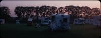 a group of campers are parked in a field