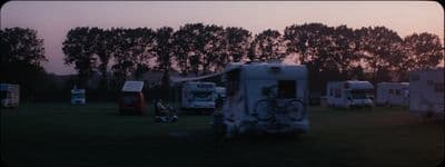 a group of campers are parked in a field