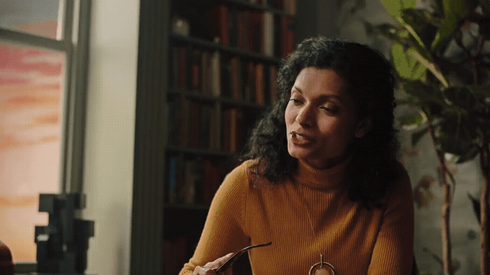 a woman sitting at a table with a pen in her hand