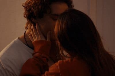 a man and a woman kissing in front of a mirror