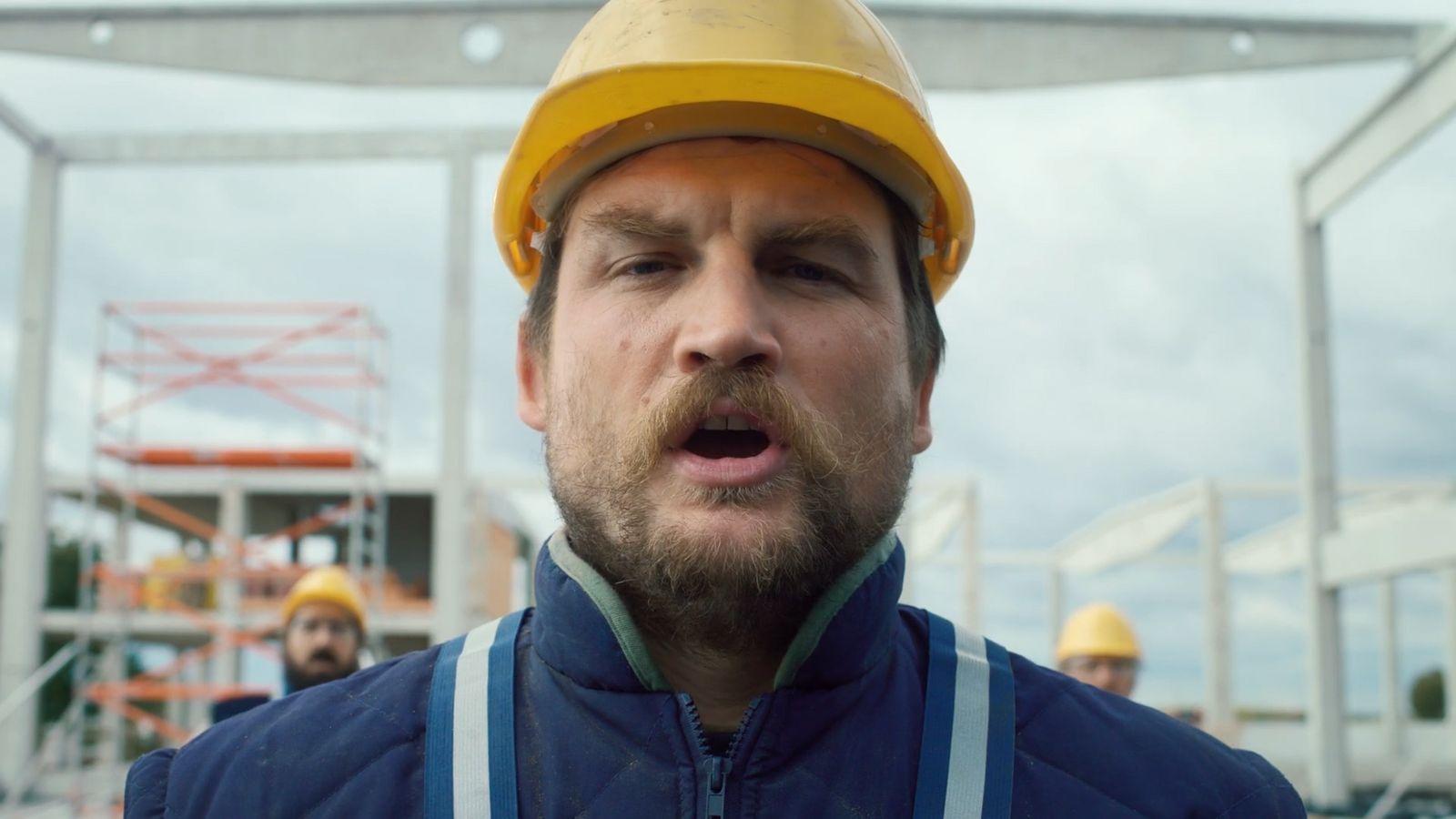 a man wearing a hard hat and blue jacket