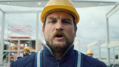 a man wearing a hard hat and blue jacket