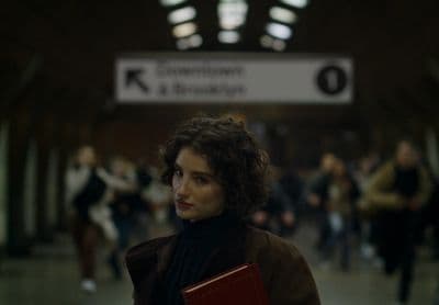 a woman holding a red folder in a train station