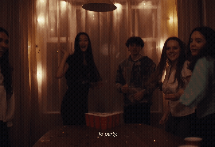 a group of young people standing around a table