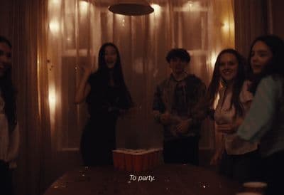 a group of young people standing around a table