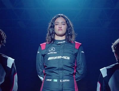 a man in a racing suit standing in front of other men
