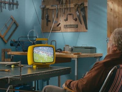 a man sitting in a chair in front of a tv