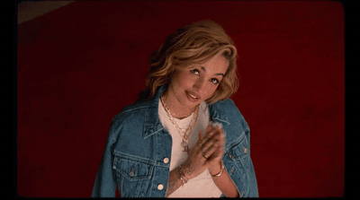 a woman in a jean jacket is posing for a picture