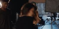 a man standing next to a woman in a recording studio