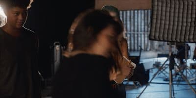 a man standing next to a woman in a recording studio