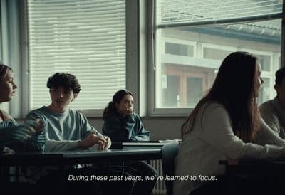 a group of people sitting at a table in front of a window