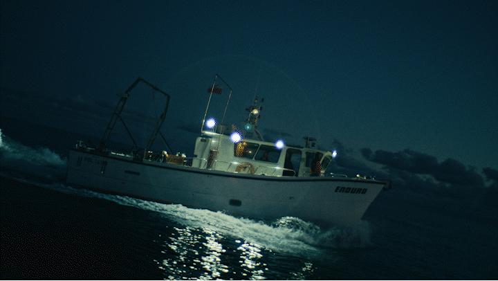 a white boat in the ocean at night