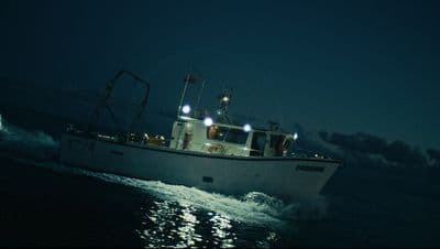 a white boat in the ocean at night