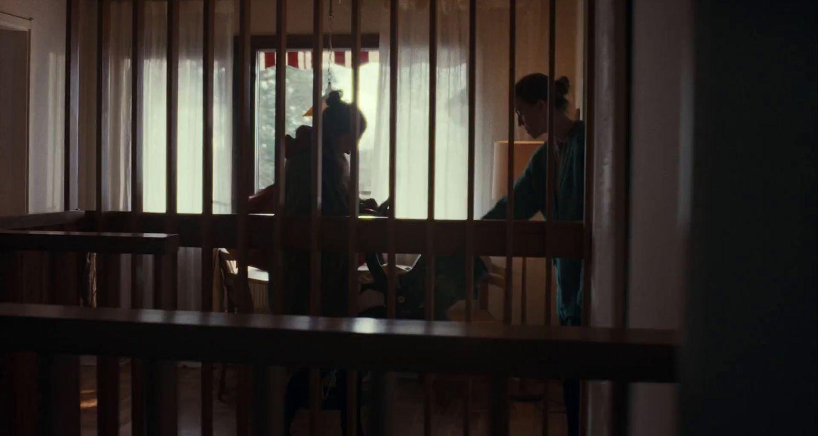a person standing in a room behind bars