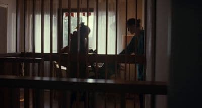 a person standing in a room behind bars