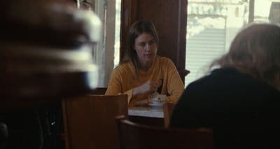 a woman sitting at a table in a restaurant