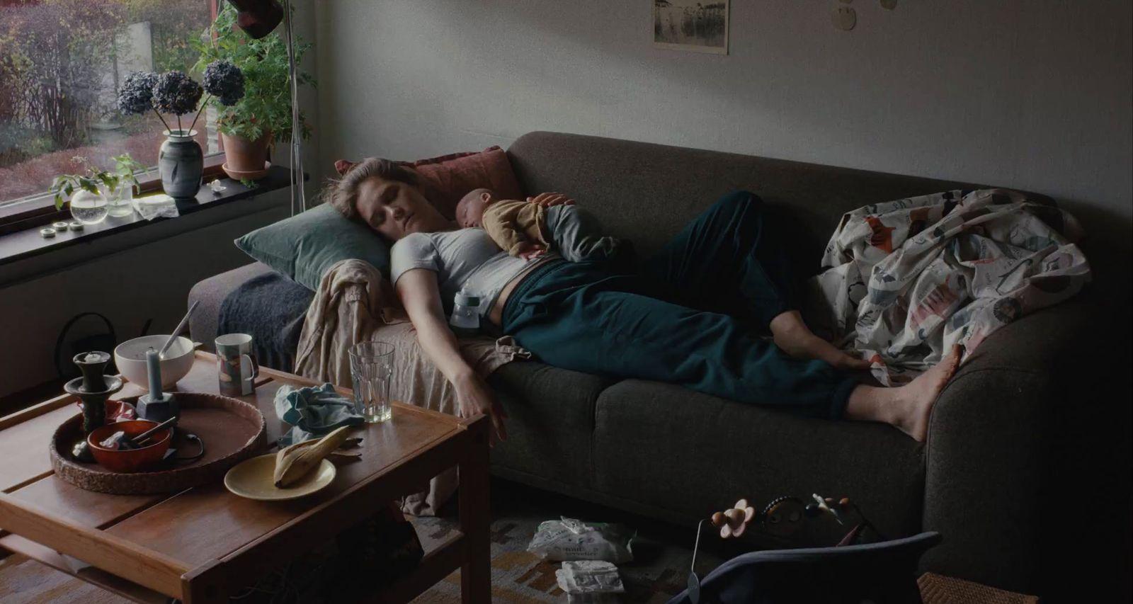 a person laying on a couch with a cat