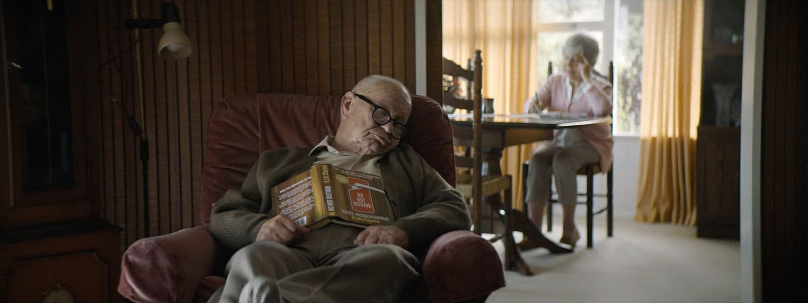 a man sitting in a chair holding a book