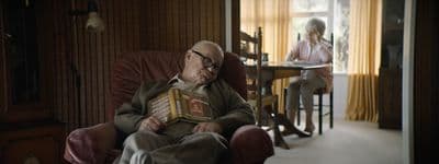 a man sitting in a chair holding a book