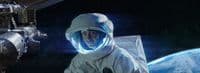a man in a space suit next to a space station