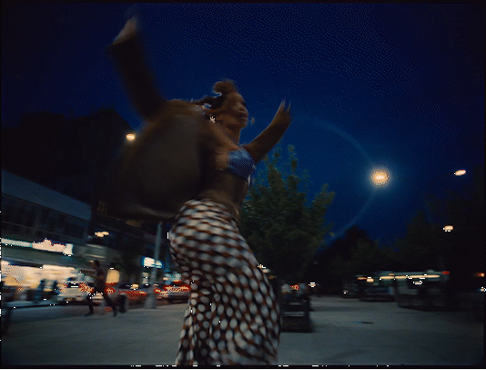 a woman walking down a street at night