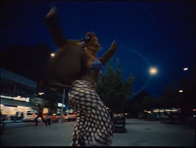 a woman walking down a street at night