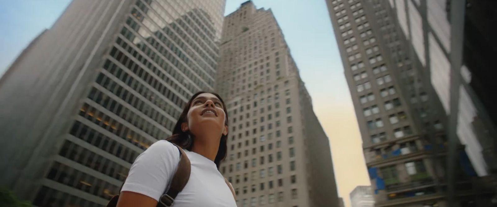 a woman standing in front of tall buildings