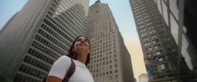 a woman standing in front of tall buildings