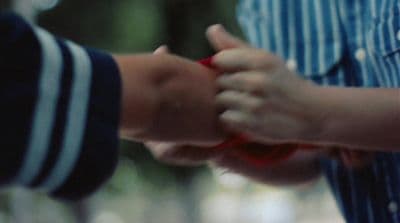 a close up of two people holding hands